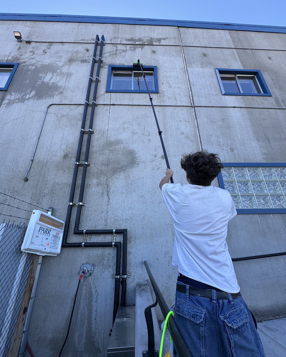 Water-fed pole reaching second-story commercial windows